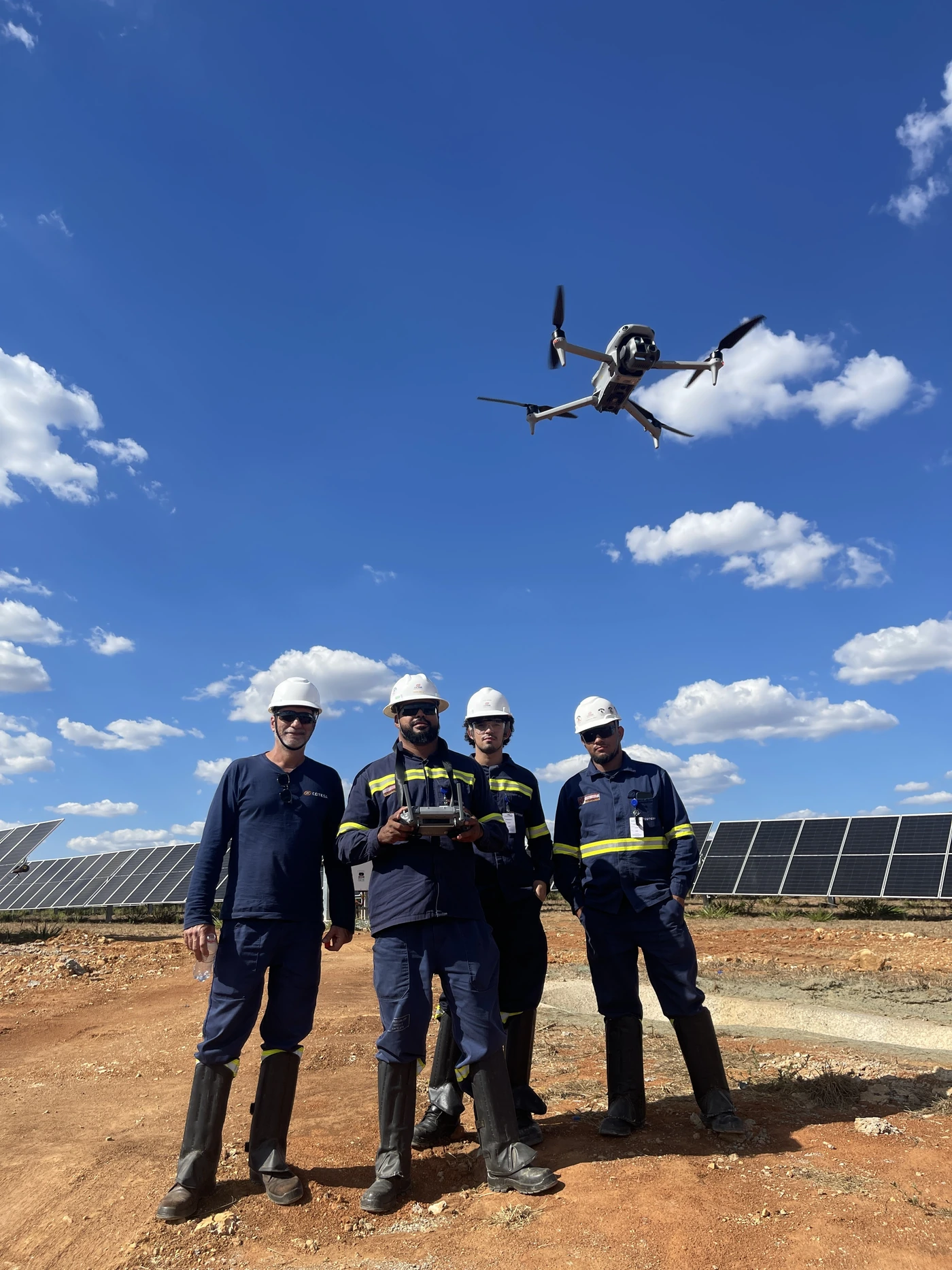 Equipe em campo com drone e painéis solares, fotografia enviada pela Flygraph